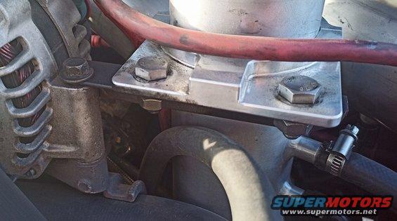 Engine component with metal bracket and red hose
