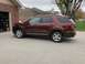 2016 Ford Explorer - A maroon Ford Explorer is parked in front of a brick garage with a basketball hoop in the background.