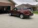 2016 Ford Explorer - A maroon Ford Explorer is parked in front of a garage and house.