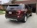 2016 Ford Explorer - The rear of a maroon 2016 Ford Explorer is visible, parked in a driveway with a garage in the background.