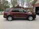 2016 Ford Explorer - The side profile of a red Ford Explorer is captured in this image, parked in front of a residential garage.