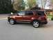 2016 Ford Explorer - A brown 2016 Ford Explorer is parked on a paved surface in front of a residential house.