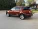 2016 Ford Explorer - A copper SUV is parked on a concrete driveway with trees and a house in the background.