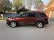 2016 Ford Explorer - A red 2016 Ford Explorer is parked in front of a brick house on a sunny day.