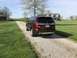 2016 Ford Explorer - A brown Ford Explorer is parked on a gravel driveway leading to a house and barn.