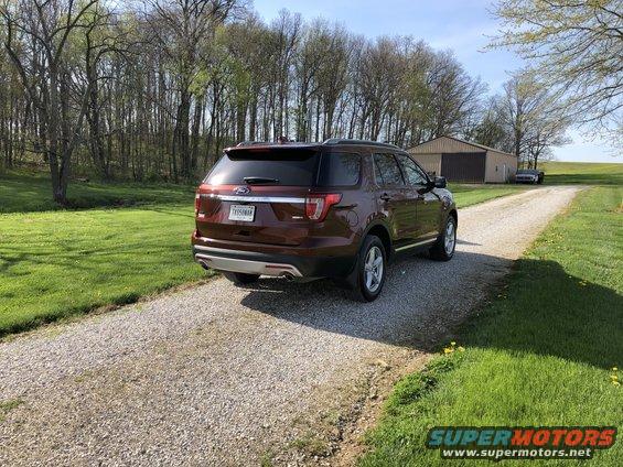 Red 2016 Ford Explorer rear view parked on gravel driveway