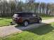 2016 Ford Explorer - Maroon SUV parked on a gravel driveway with a dog present. Body style indicates a 2011-2019 Ford Explorer.