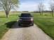 2016 Ford Explorer - A red 2016 Ford Explorer is shown from the front on a gravel driveway with a rural landscape in the background.