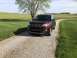 2016 Ford Explorer - A brown Ford Explorer is parked on a gravel driveway next to a grassy field.