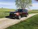 2016 Ford Explorer - This 2016 Ford Explorer is captured from a 3/4 front view, parked on a gravel road with a scenic rural landscape.