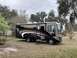 2015 Ford F-550 - A motorhome is parked in a yard with trees and a fence visible.