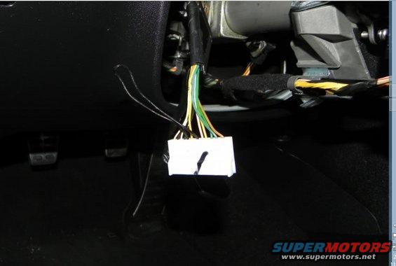 Close-up of a white wiring harness connector with multiple colored wires leading into it
