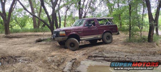 Maroon 1996 Ford Bronco on a muddy off-road trail