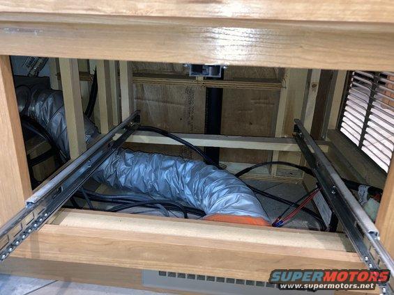 Interior ductwork and wiring behind wooden cabinets