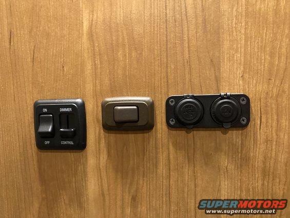 Interior control panel with a dimmer switch, an on/off switch, and two 12V power outlets mounted on wood paneling
