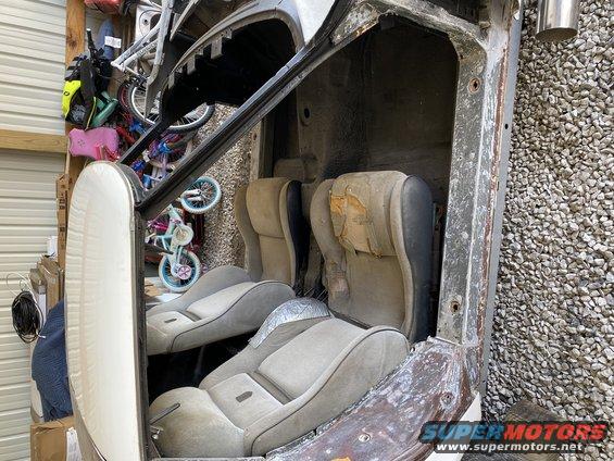 Car interior showing worn bucket seats and door panel, with bicycles in the background