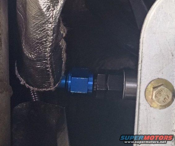 Blue AN fitting on a transmission cooler line, with heat-reflective wrap