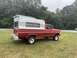 2002 Ford Excursion - This vintage Ford pickup truck is equipped with a camper shell, suggesting it was used for recreational purposes.