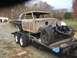 1963 Ford Galaxie - A car body, stripped down and showing rust, is being transported on a trailer.