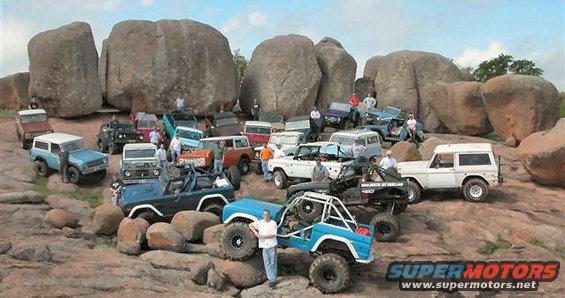 group of off-road vehicles and people gathered on rocks