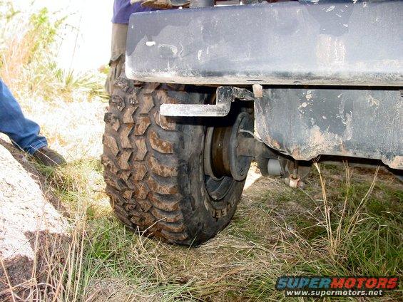 Mud-splattered rear bumper and large off-road tire on a vehicle