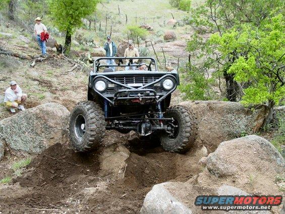 1973 Ford Bronco modified for off-roading climbing over rocks