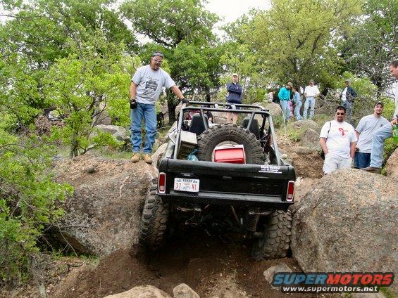 Black 1973 Ford Bronco rear view navigating rocks