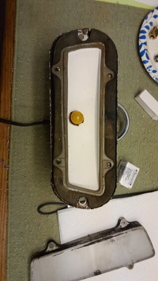 img_20231116_105205740.jpg passenger side front marker light with the top lens removed showing the original bulb and gasket.  I applied rubber preservative to the gasket and cleaned up the fixture before putting in the LED and reassembling.