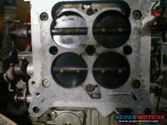 Four-barrel carburetor with visible throttle plates and linkage