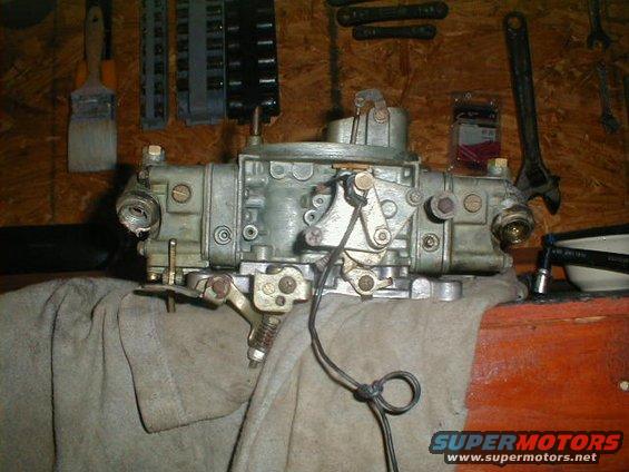 Carburetor on a workbench with tools in the background