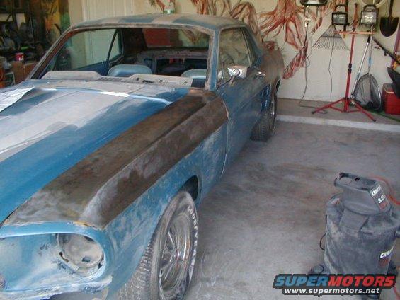 1967 Ford Mustang coupe undergoing restoration, primer on hood and fender