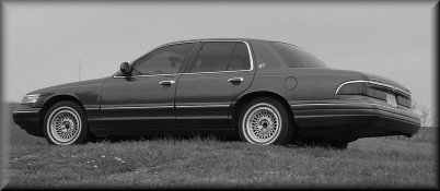 1995 Mercury Grand Marquis parked on grassy field, side view