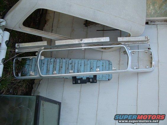 Ford Bronco grille assembly with blue backing and some white body panels nearby