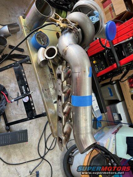 6-tacked-up-again.jpg Inserted one 10-degree pie cut and tacked everything up again. This time the end of the pipe ended up a little close to the steering shaft. Another adjustment was required but it was just about a 4-degree slice right under the #1 header tube. This made it clear the corner of the head, the steering shaft, the header tubes, the sparkplug wire boots, and everything else in there. It's not a tight fit though either, just a lot of things to keep in mind.