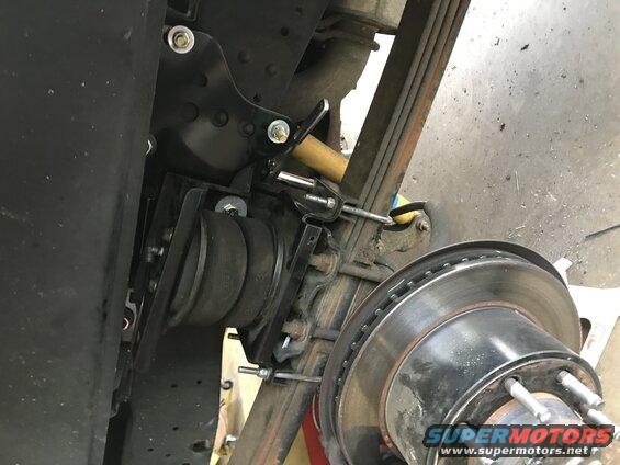 Close-up of an air suspension component installed on a truck's rear axle, near the brake rotor