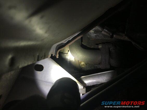 Close-up of an exhaust pipe and metal bracket under a vehicle
