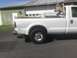 2008 Ford F-250 - The rear of a white 2008 Ford F-250 pickup truck is visible, equipped with a utility bed and ladder rack.
