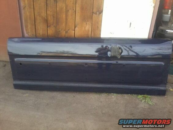 Dark gray tailgate with horizontal lines and a central latch mechanism
