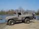 1979 Ford Bronco - A muddy 1978 Ford Bronco sits by the water, with a person perched on its rear bumper.