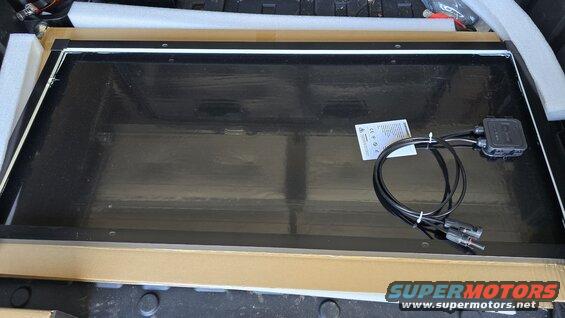 Solar panel with cables and junction box, sitting in packaging