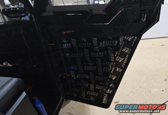 Interior of a vehicle door with sound deadening material applied to the panel