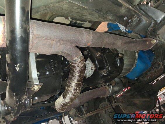 Exhaust pipe with heat wrap and transmission housing
