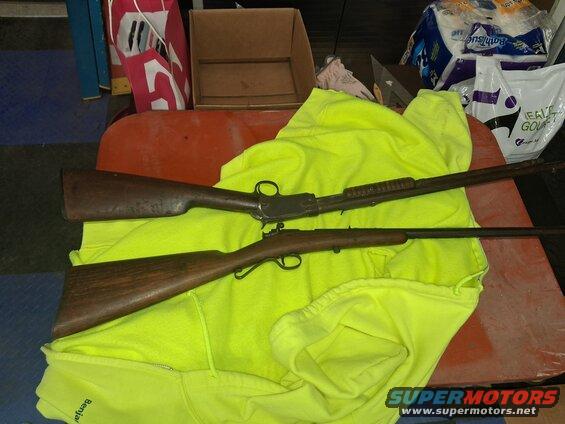 Two rifles, one lever-action and one bolt-action, laid out on a bright yellow sweatshirt
