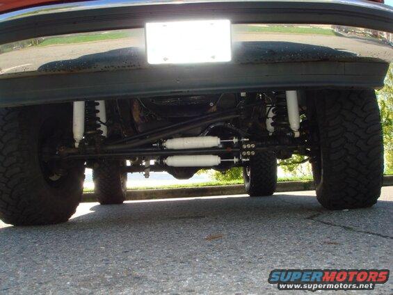 Underside of a lifted Ford Bronco with off-road tires and suspension components.