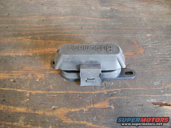 Black Bussmann fuse holder with rubber cover on a wooden surface