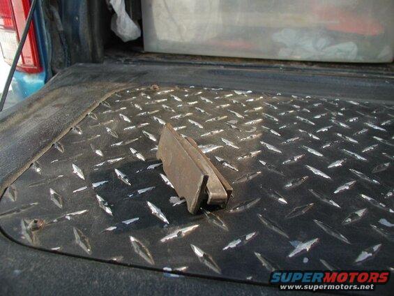 Metal bracket on diamond plate truck bed liner