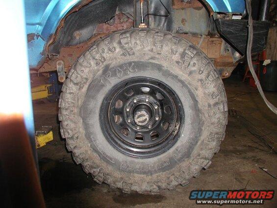 Off-road tire on a rusty blue vehicle.