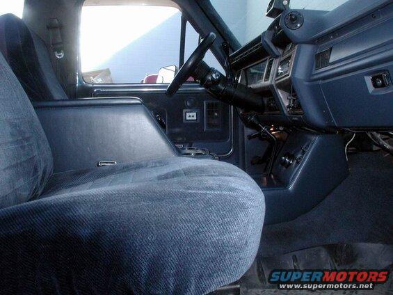 Interior of a blue Ford Bronco, showing driver's seat, center console, and dashboard.