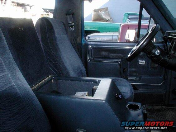 Interior of a blue Ford Bronco showing seats, steering wheel, and center console.