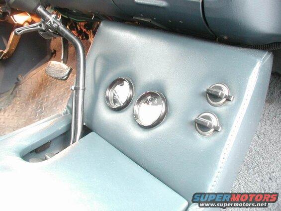 Custom center console with gauges and switches in a vehicle interior.